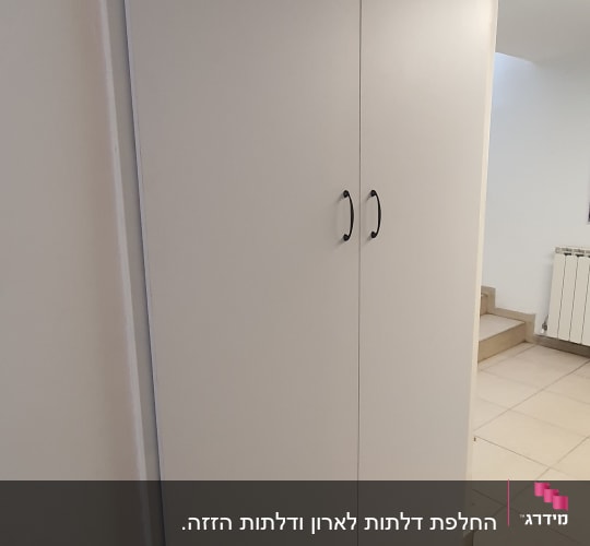 ארון עץ עם שתי דלתות וידיות שחורות